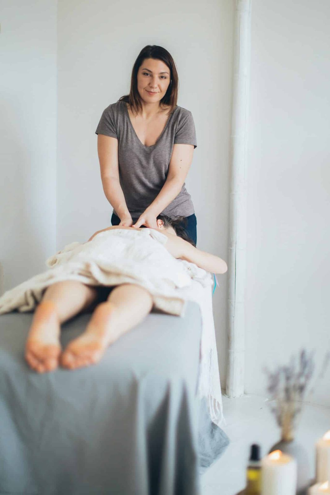 woman giving massage  to person lying on the bed
