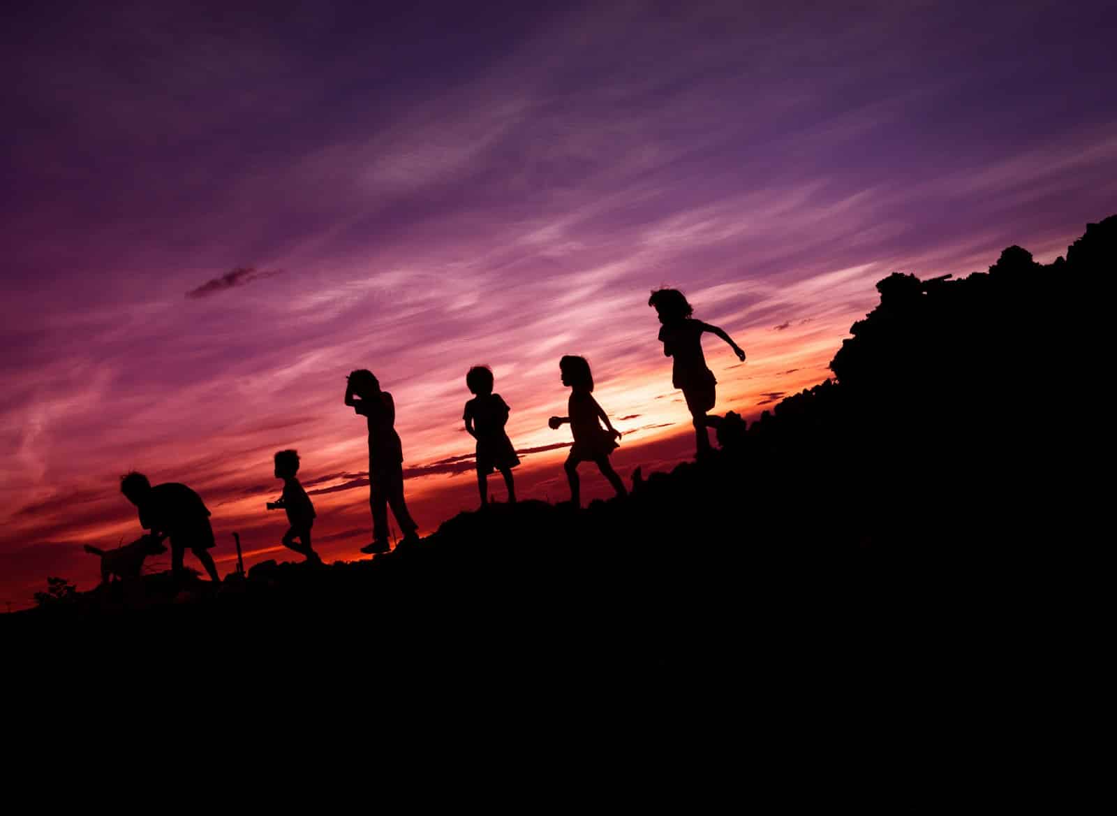 Silhouette of children running on hill in sunset. Local Paediatric Physio Near You in Wavell Heights.