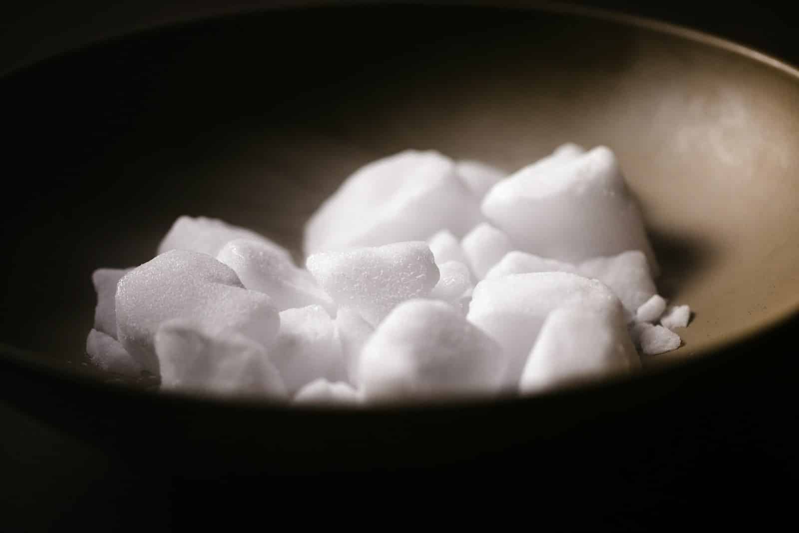 white sugar cubes in black bowl. Science of Sugar Addiction 