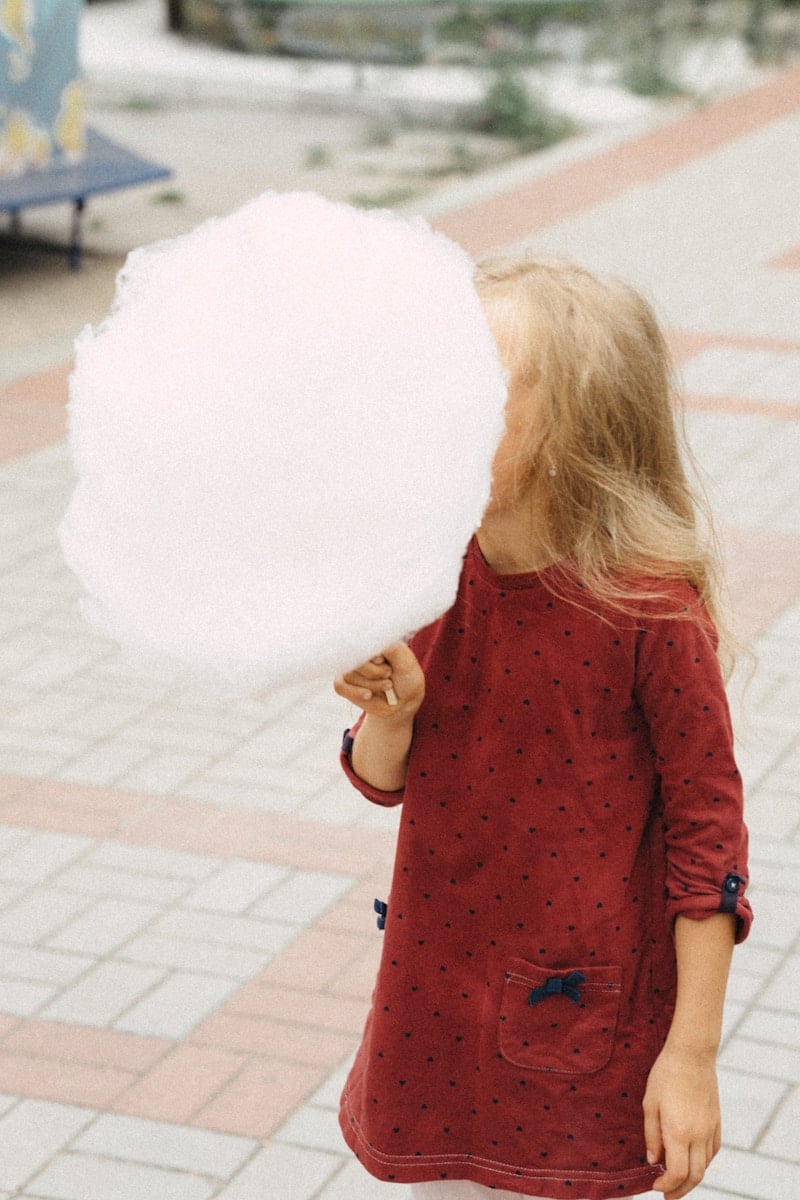 A little girl holding a large fairy floss - The Science Behind Sugar Addiction